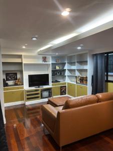 a living room with a couch and a flat screen tv at Family room in Bang Kapi