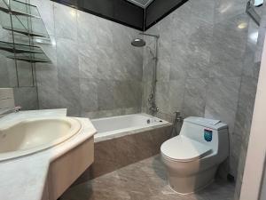 a bathroom with a toilet and a tub and a sink at Family room in Bang Kapi