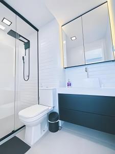 une salle de bain blanche avec toilettes et douche dans l'établissement Flat Luxo 35º Andar • Vista Incrível da Cidade, à Goiânia