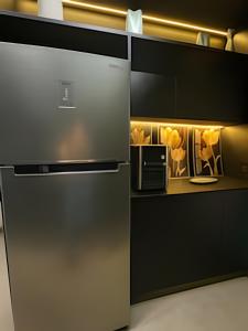 une cuisine avec un réfrigérateur et un micro-ondes dans l'établissement Flat Luxo 35º Andar • Vista Incrível da Cidade, à Goiânia