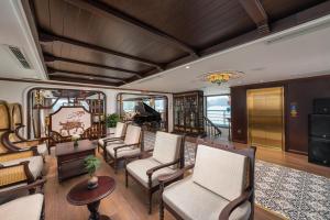 a train car with chairs and a piano at Lamour Cruise in Ha Long