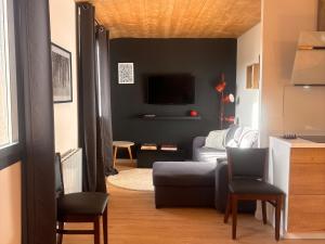 un soggiorno con un divano e una TV di Appartement rénové T2 mezzanine Formiguères, 10 pers, proche commerces - FR-1-758-46 a Formiguères