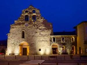 un grande edificio in pietra con una torre dell'orologio di notte di Appartement rénové T2 mezzanine Formiguères, 10 pers, proche commerces - FR-1-758-46 a Formiguères