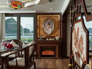a living room with a fireplace and a table and chairs at Lamour Cruise in Ha Long
