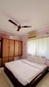 ein Schlafzimmer mit einem weißen Bett mit Deckenventilator in der Unterkunft Silver ok appartment in Shirdi