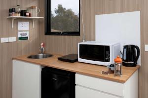 Una encimera de cocina con un microondas y un fregadero. en The Bunjil by Tiny Away, en Steels Creek