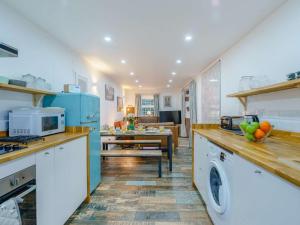 una cucina con elettrodomestici blu e una sala da pranzo di 4 Bed in Gosforth 85807 a Gosforth