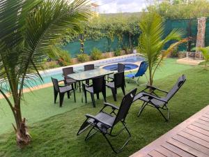 a table and chairs in a yard next to a pool at Habitacion en Villakite ,Salinas del Rey in Juan de Acosta