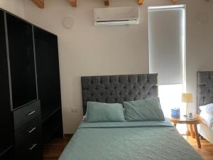 a bedroom with a bed with a headboard and a dresser at Habitacion en Villakite ,Salinas del Rey in Juan de Acosta