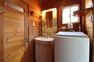 ein kleines Badezimmer mit Waschbecken und Spiegel in der Unterkunft ウィークリー宿家里 in Akaren + 52 Fotos