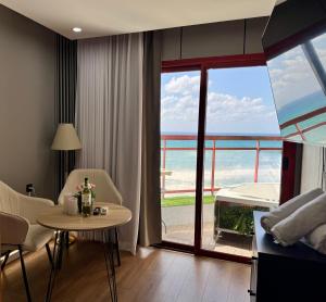 a living room with a view of the ocean at קו המים-סוויטה עם גקוזי במרפסת על הטיילת! in Netanya