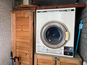 eine Waschmaschine auf einem Schrank in der Unterkunft ウィークリー宿家里 in Akaren