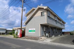 ein kleines Gebäude am Straßenrand in der Unterkunft ウィークリー宿家里 in Akaren