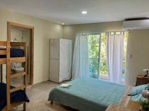 una camera con letto, frigorifero e finestra di Corales Punta Cana a Punta Cana