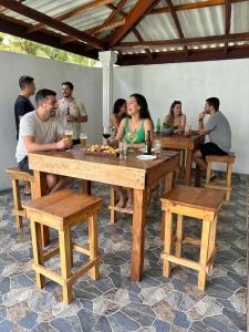 a group of people sitting at wooden tables at Soluna Hostel in Ahangama