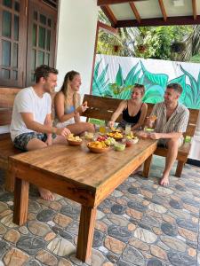 a group of people sitting around a wooden table at Soluna Hostel in Ahangama