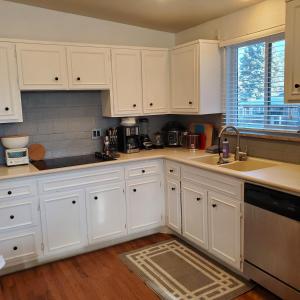 een witte keuken met witte kasten en een spoelbak bij 7 bedroom 8 beds family house in Denver