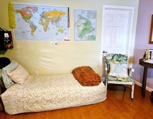 a bedroom with a bed and a chair and a map on the wall at Hale Mapuana in Pahoa