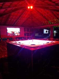 un tavolo da ping pong in una stanza con TV di Rancho vale encanto a Araguari