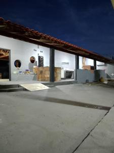 un edificio bianco con due finestre e un tetto di Rancho vale encanto a Araguari Altre 20 foto