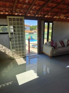 un soggiorno con un divano e una porta scorrevole in vetro di Rancho vale encanto a Araguari
