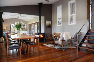 a dining room with a table and a fireplace at The Welcome Paddock in Hepburn