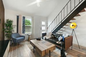 a living room with a black leather couch and stairs at Contemporary Couples Getaway Near Austin Favorites - Loft 21 in Austin +10 photos