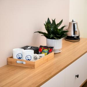 een houten dienblad met koffiekopjes en een plant op een aanrecht bij The Moon's House in Mộc Châu