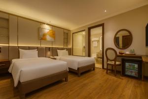 a hotel room with two beds and a mirror at Splendid Secret Hotel in Hanoi +54 photos