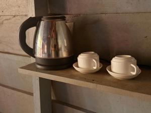 a tea kettle and three cups on a shelf at Prey Apsara Bungalows in Koh Rong