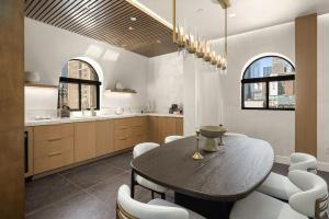 Luxury Penthouse with Empire State Views in NYC في نيويورك: مطبخ مع طاولة خشبية وكراسي بيضاء +15 صورة