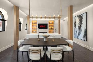 Luxury Penthouse with Empire State Views in NYC في نيويورك: غرفة طعام مع طاولة وكراسي بيضاء