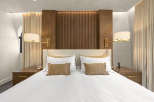 Luxury Penthouse with Empire State Views in NYC في نيويورك: غرفة نوم بها سرير أبيض كبير مع وسادتين