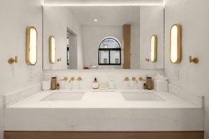 Luxury Penthouse with Empire State Views in NYC في نيويورك: حمام به مغسلتين ومرآة كبيرة