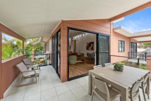 バイロンベイにあるKeesing Villa 8のバルコニーにテーブルと椅子が置かれたダイニングルーム