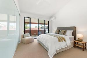 バイロンベイにあるKeesing Villa 8の白いベッドルーム(大型ベッド1台、椅子付)