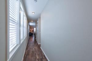 CarltonAdventure Awaits - Wine country oasis w Cozy deck的一条走廊，有白色窗户和木地板。