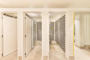 オークランドにあるJO&JOE Aucklandの白い壁と白黒の模様のドアのある廊下 +25枚の写真