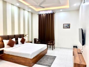 ein Schlafzimmer mit einem Bett und einem Fernseher darin in der Unterkunft Murthal Green Plaza Hotel in Sonīpat