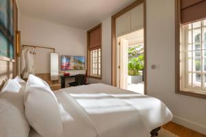 a white bedroom with a white bed and a window at 1926 Heritage Hotel Penang by The Unlimited Collection in George Town