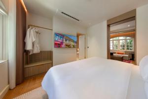 a bedroom with a white bed and a walk in shower at 1926 Heritage Hotel Penang by The Unlimited Collection in George Town