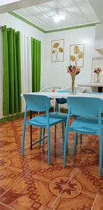 een blauwe tafel en stoelen in een kamer met groene gordijnen bij Liberty's Homestay in Coron +10 foto's