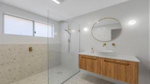 ein Badezimmer mit Waschbecken und Spiegel in der Unterkunft Luxe Hideaway - South Umina in Umina + 16 Fotos