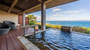 a swimming pool on a deck with a view of the ocean at Hamachidorinoyu Kaisyu in Shirahama