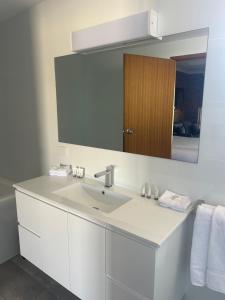 ein Badezimmer mit einem weißen Waschbecken und einem Spiegel in der Unterkunft Travellers Rest Motor Inn Swan Hill in Swan Hill