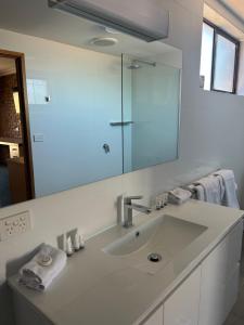 ein Badezimmer mit Waschbecken und großem Spiegel in der Unterkunft Travellers Rest Motor Inn Swan Hill in Swan Hill