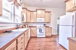 une cuisine avec des armoires en bois et un réfrigérateur blanc dans l'établissement The Pink House - Pets OK Victorian Near 3rd Street, à McMinnville 15 autres photos