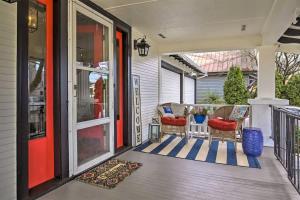 a porch with a red door and two chairs at 5th St Bungalow - Historic Charm Near 3rd St in McMinnville