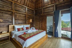 una camera da letto con un letto a cigno sopra di Jatiluwih Guava Eco Living managed by Manara a Jatiluwih