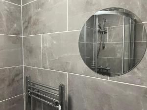 ein Bad mit einem Spiegel und einer Dusche in der Unterkunft Rare 4 en-suite Bedroom Flat with Free Parking and workspace in Warwick + 27 Fotos